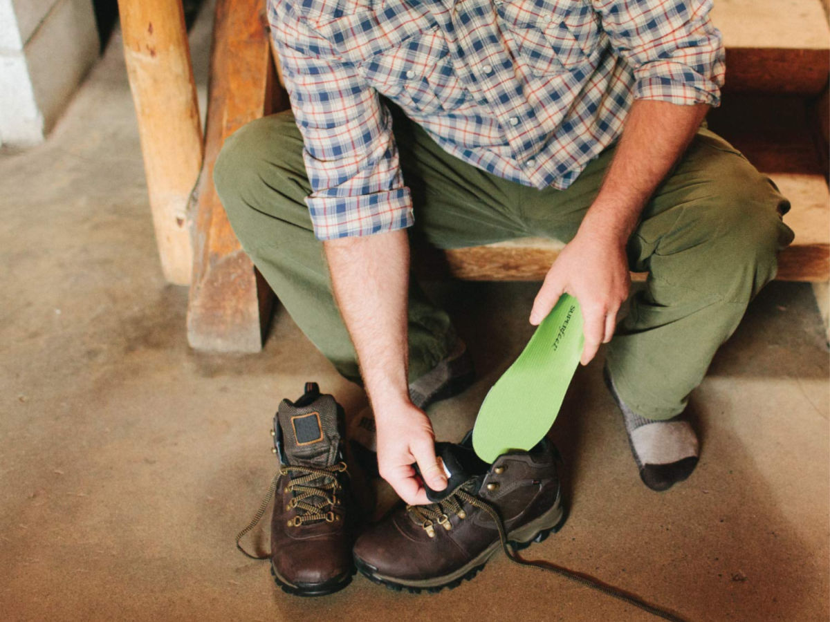 Man putting Superfeet Green Insoles in his Boots