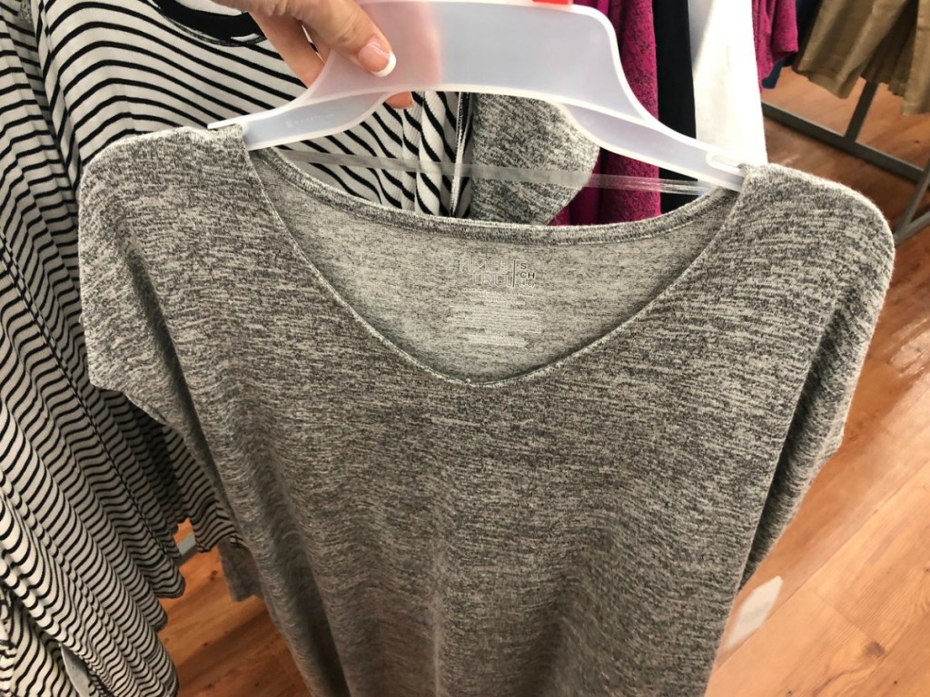 hand holding grey dress in store on hanger