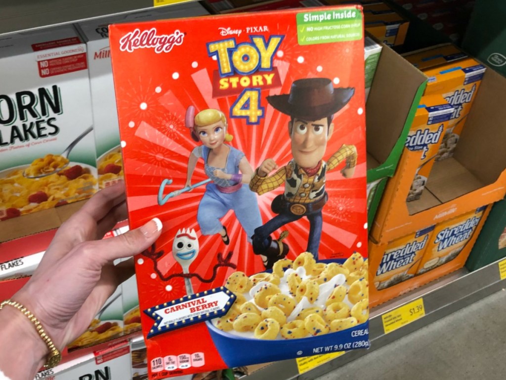 hand holding red box of cereal near store shelf