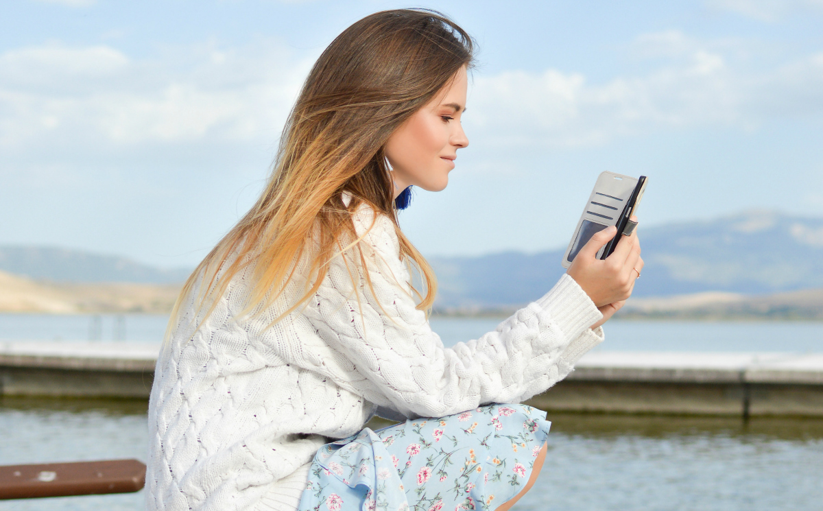 woman reading book on smartphone