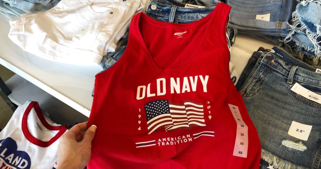 womans hand holding red old navy flag tank top in store near white and denim jeans