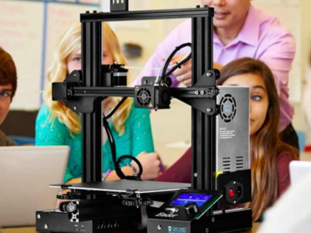 people in a classroom using a 3D printer