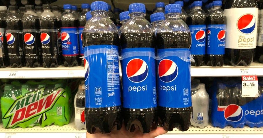 hand holding bottles of soda