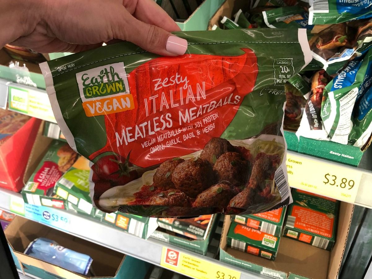 hand holding bag of Earth Grown Vegan Zesty Italian Meatless Meatballs in ALDI store