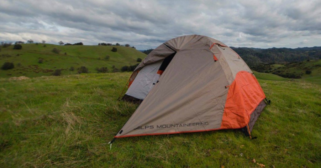 Two-person tent set up with rain fly in the grass
