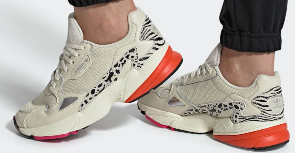 Woman wearing Adidas Falcon Shoes in coral, cream and animal print