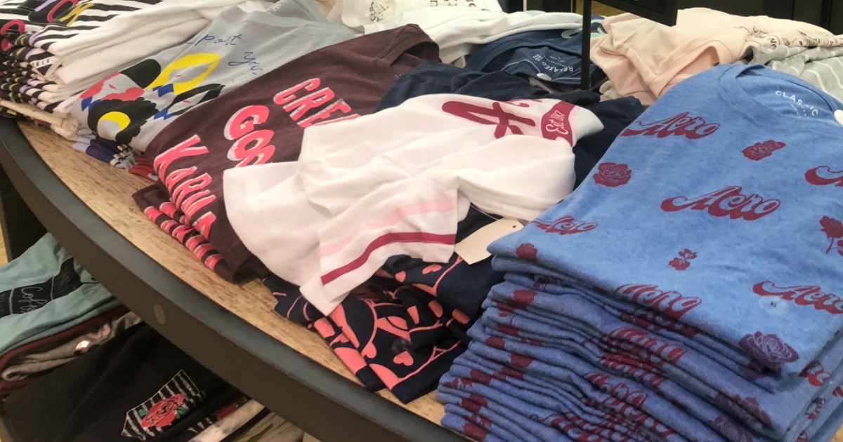 graphic tees stacked and folded on a table in a store