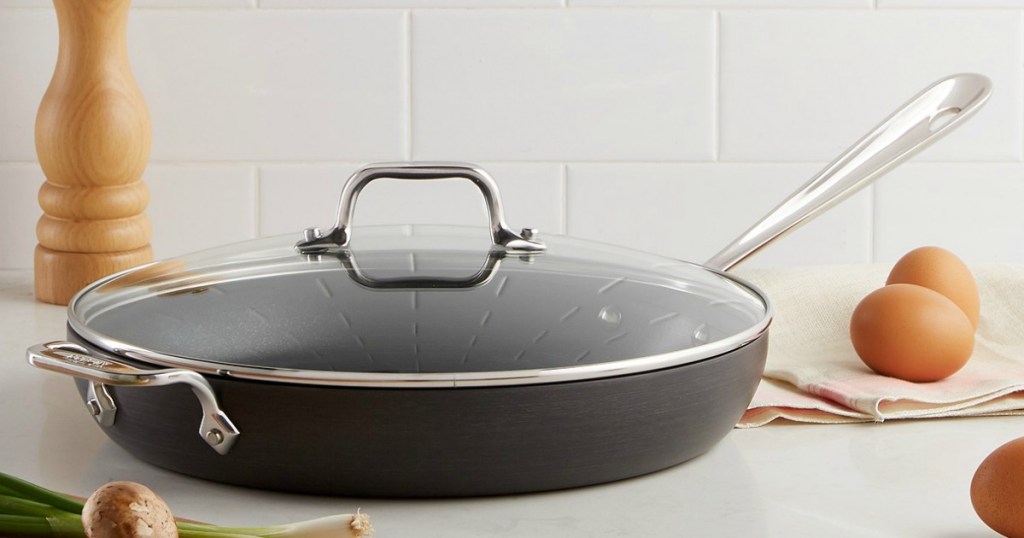 All-Clad Hard Anodized 12" Fry Pan with Lid on a table with food