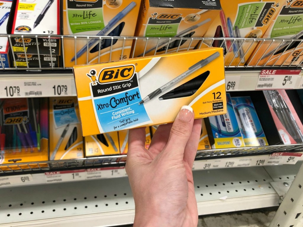 Bic ballpoint pens held up in front of supply bins
