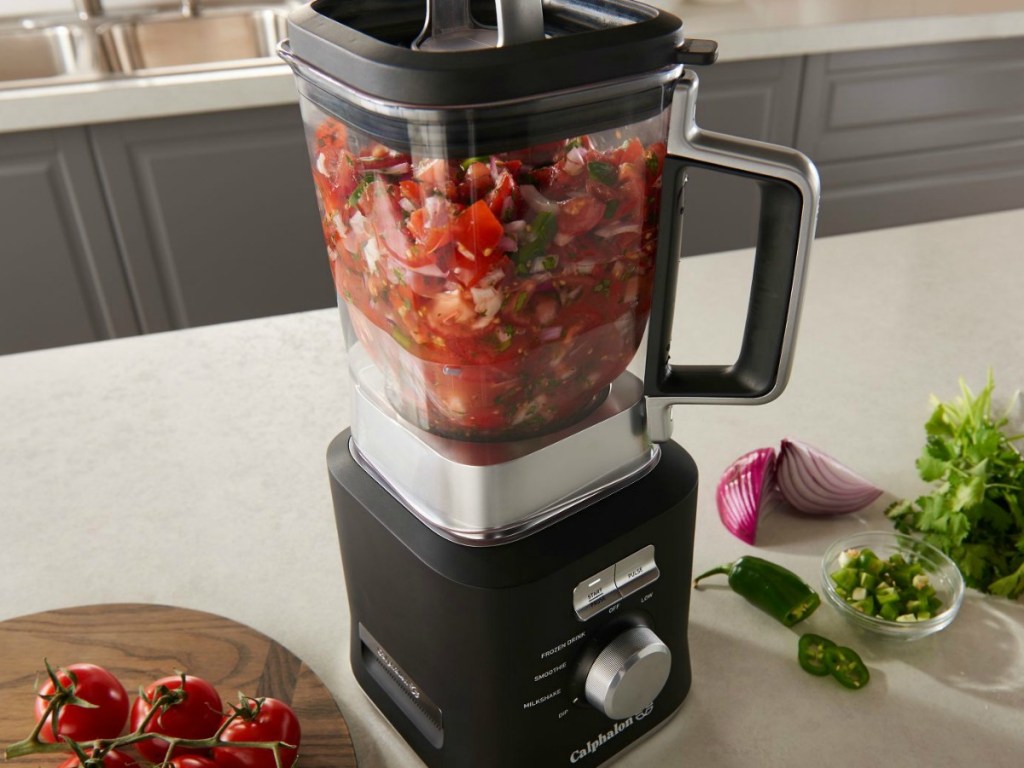 Calphalon blender with salsa in jar and vegetables surrounding blender on counter