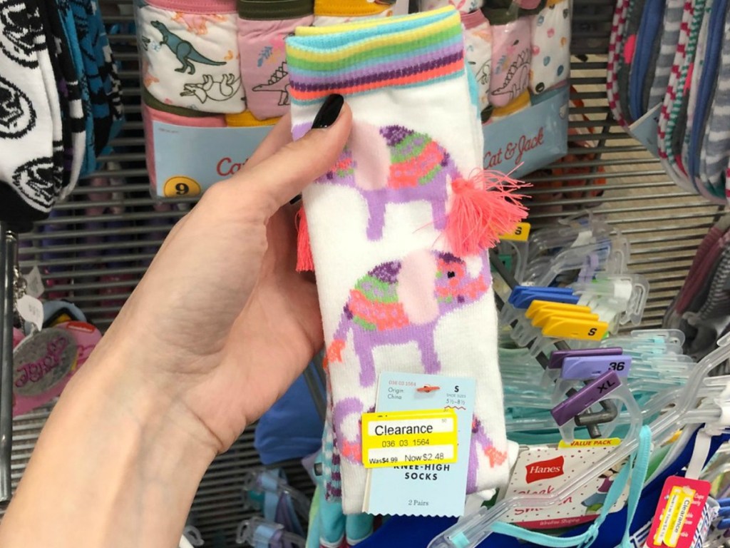 hand holding socks with elephants at store