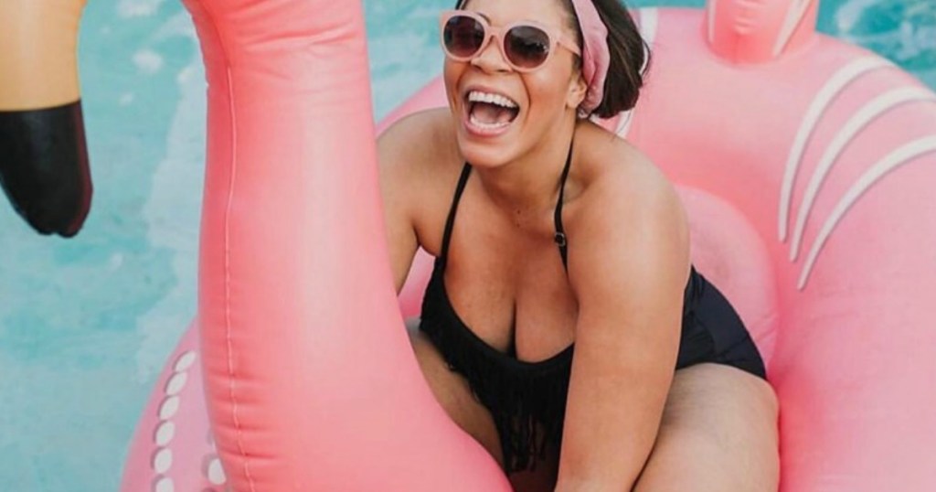 Woman wearing black swimsuit on flamingo float