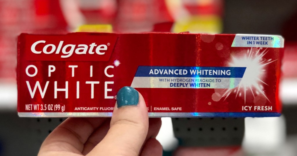 Hand holding Colgate Optic White Toothpaste