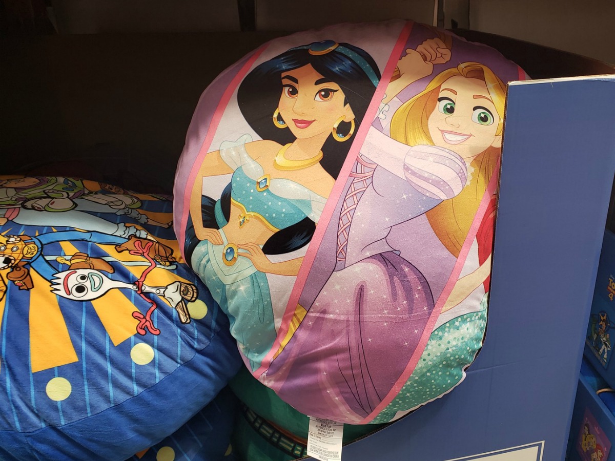 Disney Princess and Toy Story 4 floor seating cushions in a store bin
