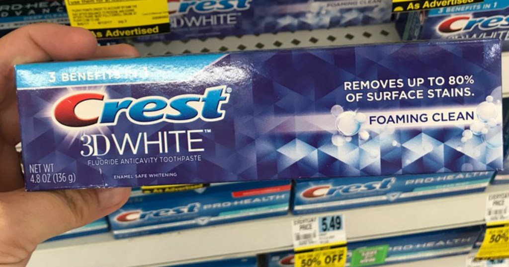 Crest 3D White Toothpaste being held by a woman's hand
