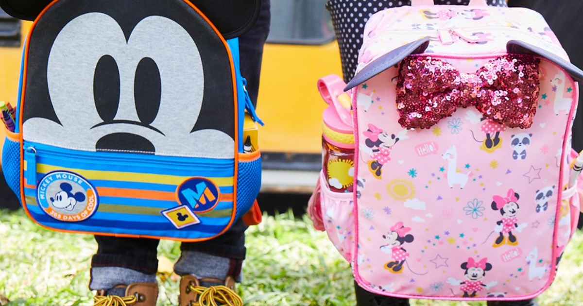 Kids holding Mickey & Minnie Mouse Backpacks in front of school bus