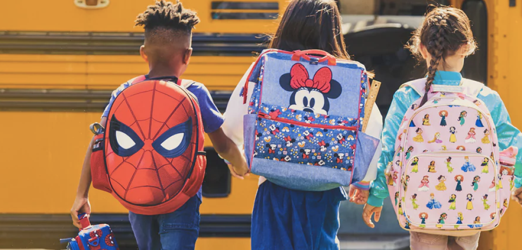 Kids wearing Disney backpacks and walking to school bus