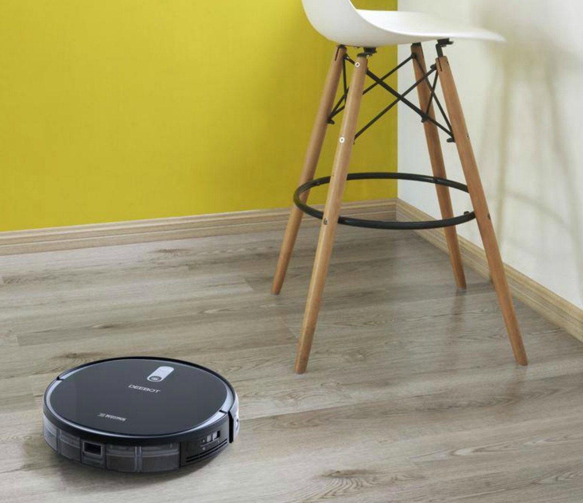 Smart Vacuum from ECOVAC on hardwood floor near stool