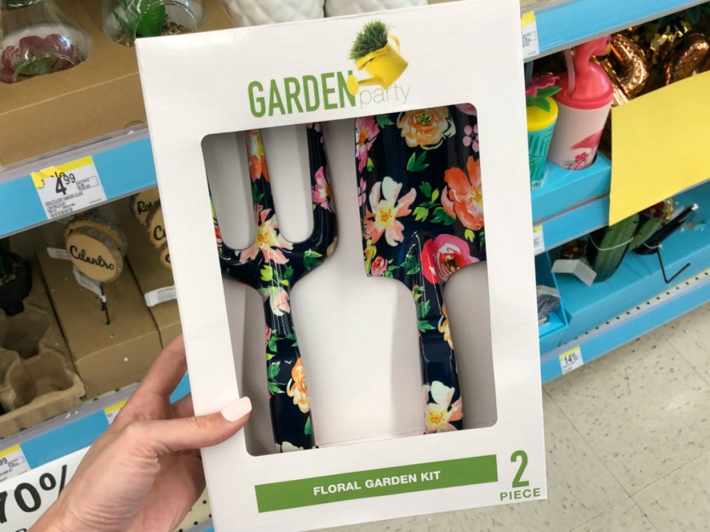 hand holding box with garden tools by store display