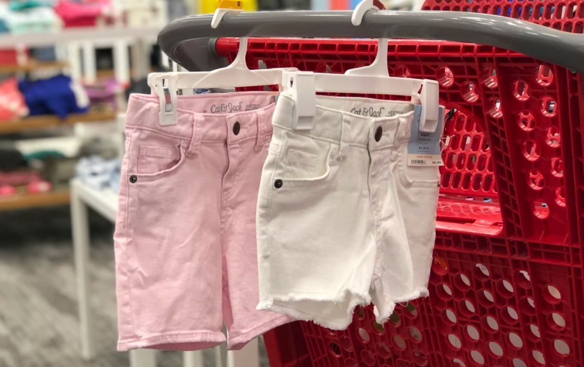 Girls denim shorts in white and pink on hangers on Target cart in store