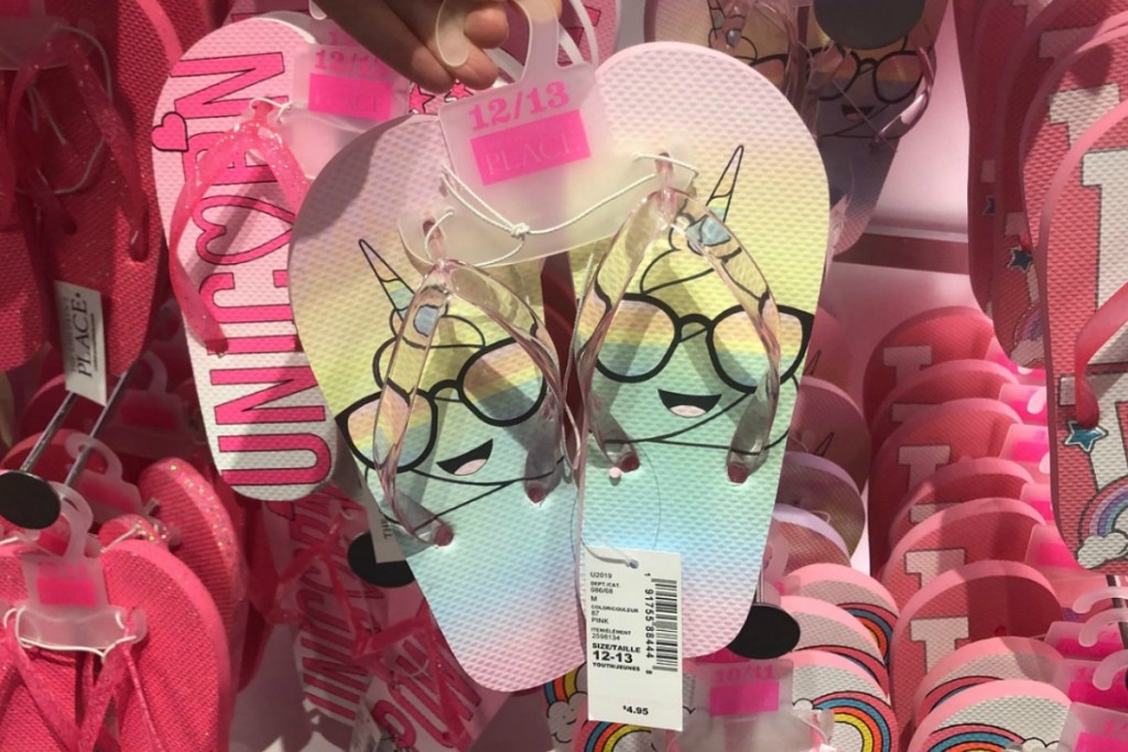 rainbow colored girls flip flops with swirl emoji design in store