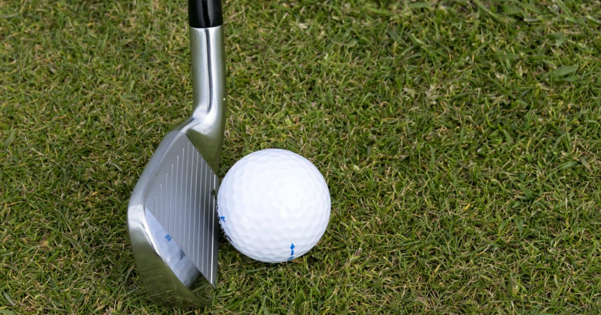 golf club and golfball on green