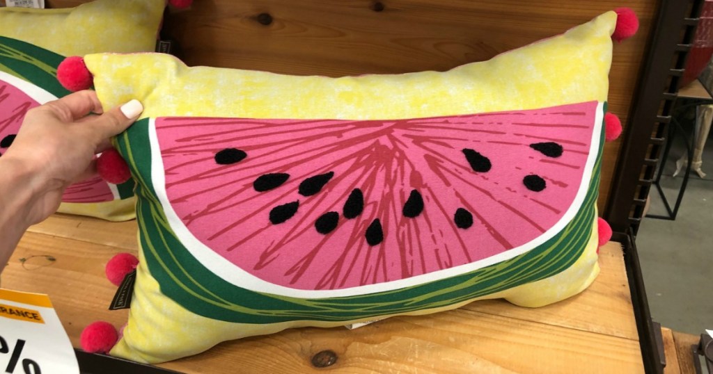 hand holding watermelon pillow in store