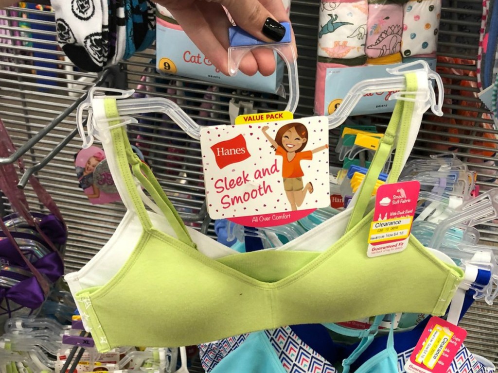 hand holding bra on a hanger in store