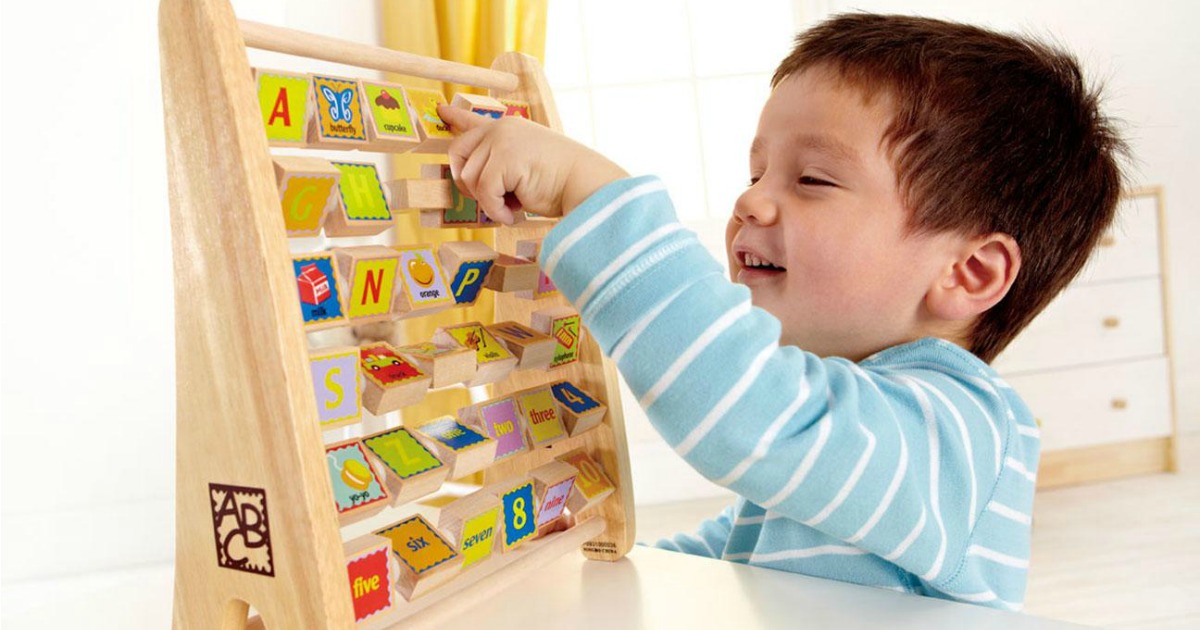 young boy playing with alphabet abacus from Hape