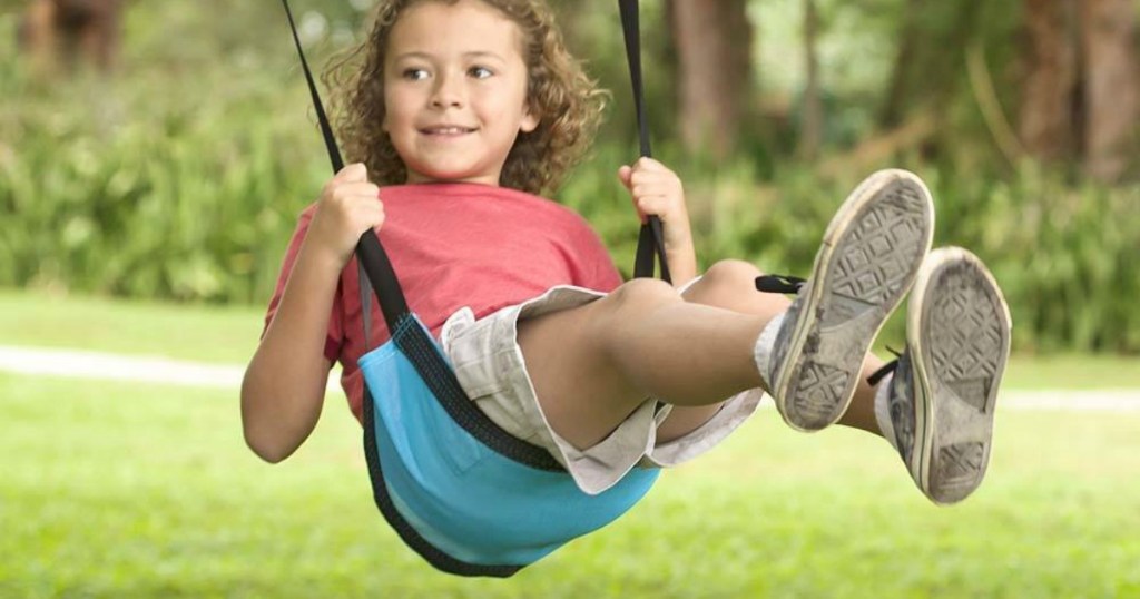 Boy swinging on a sling-shaped swing in blue 