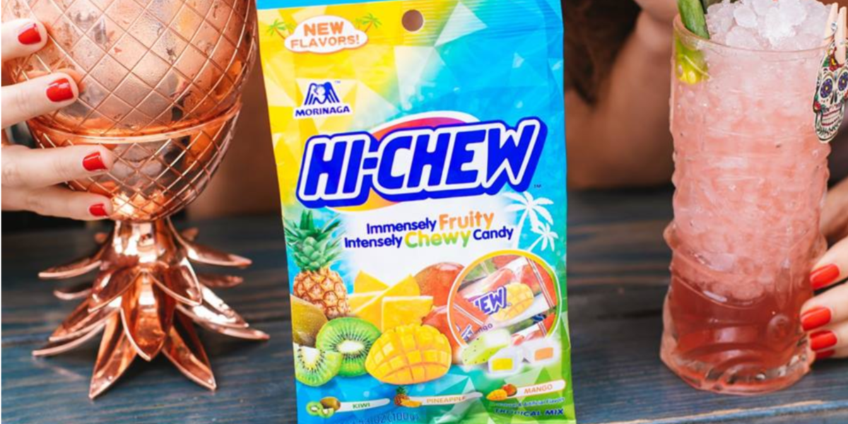 Hi Chew Tropical Mix next to a drink on a table