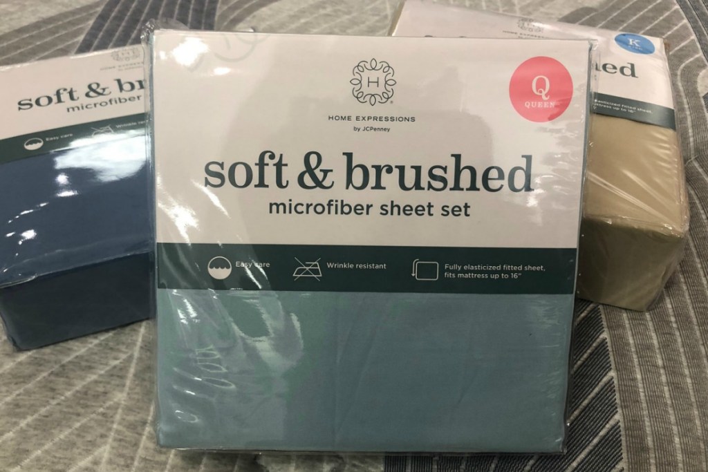 Teal colored Queen size sheet set on top of two other sets of sheets in package
