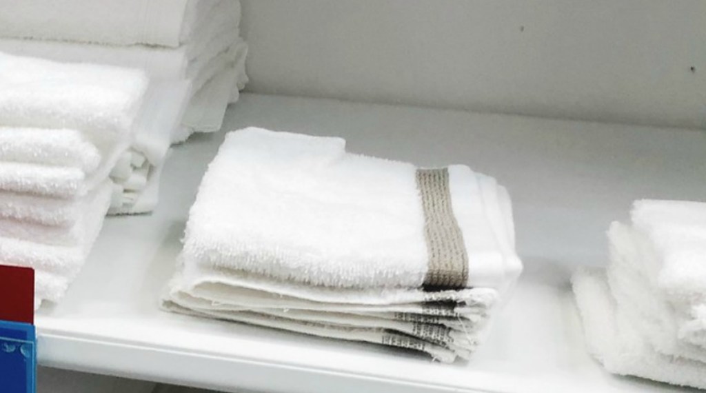 White wash cloth with golden stripe on store shelf at JCPenney