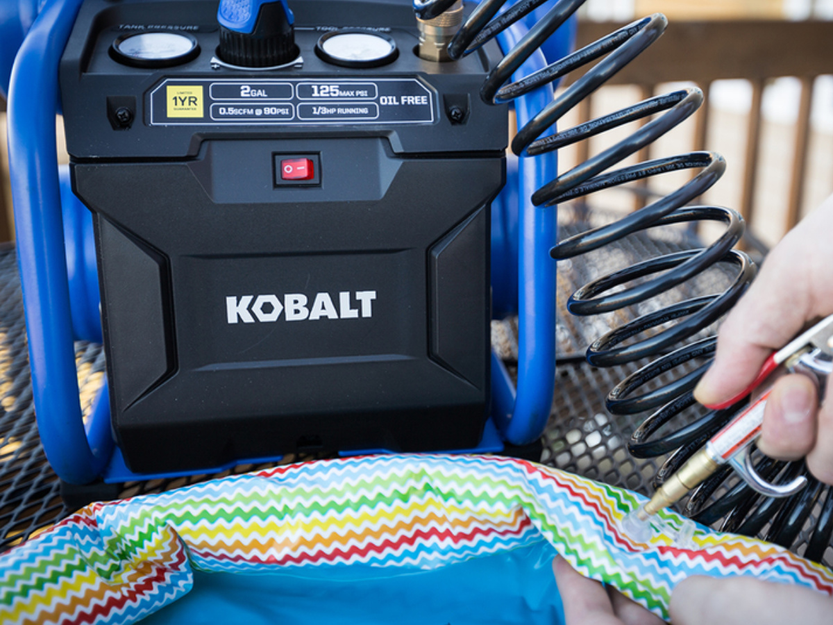close up of a Kobalt Air Compressor inflating a pool toy
