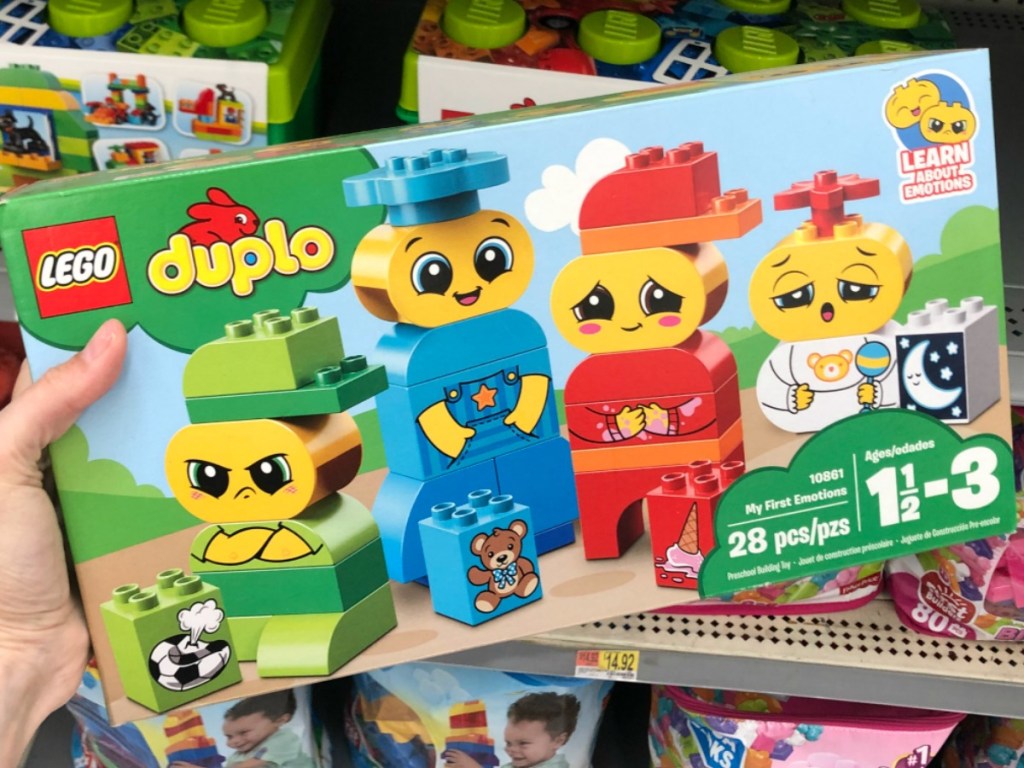 hand holding box of duplos with faces in store