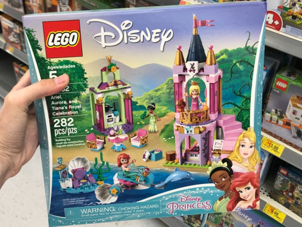 hand holding up pink castle lego set in store