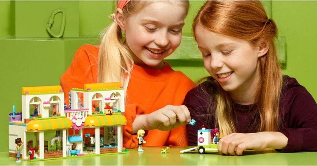 two girls playing with a LEGO building set