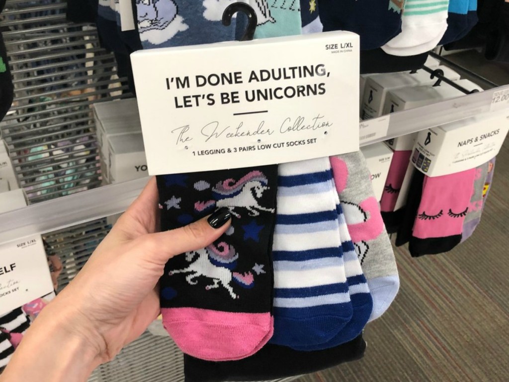 hand holding set of socks in store with unicorns