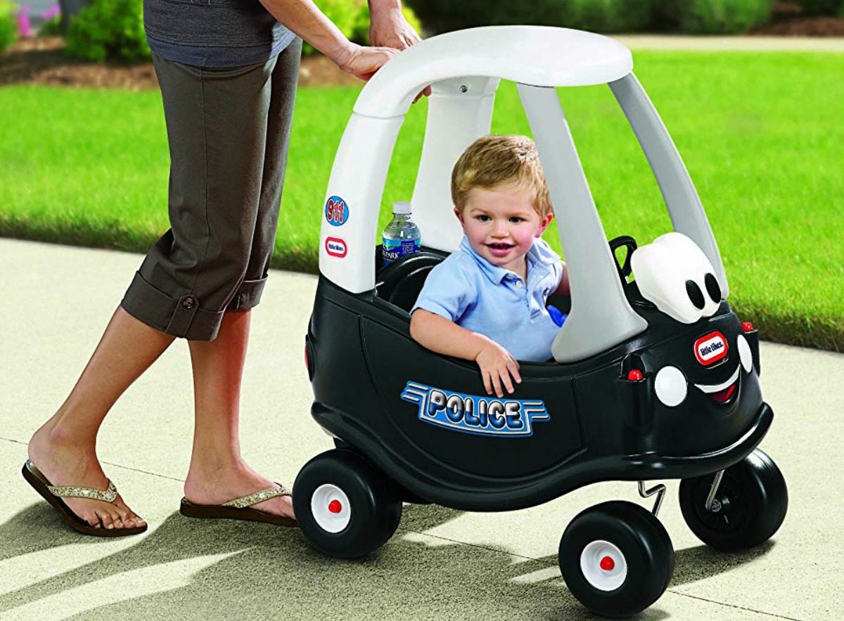 Mom walking with toddler son in Little Tikes Cozy Coupe