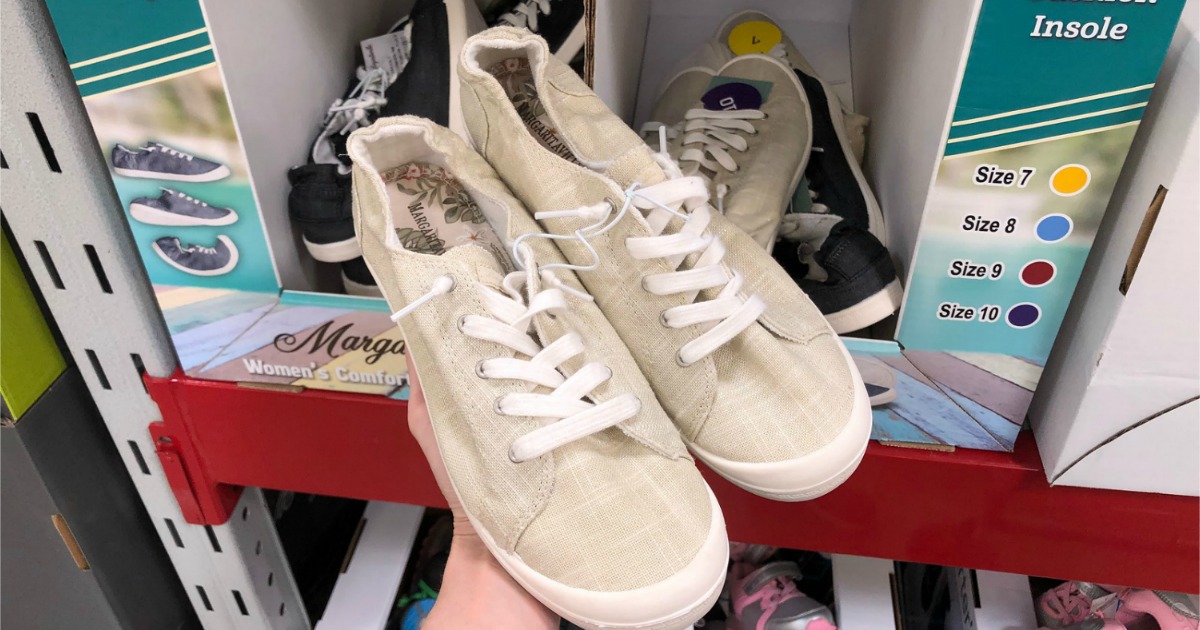 hand holding a pair of tan MargaritaVille Canvas shoes in store