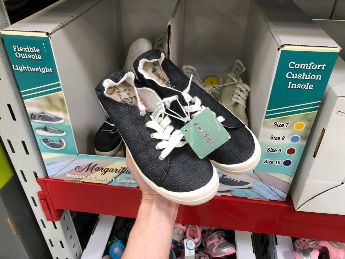 hand holding a pair of black Margaritaville canvas shoes in store