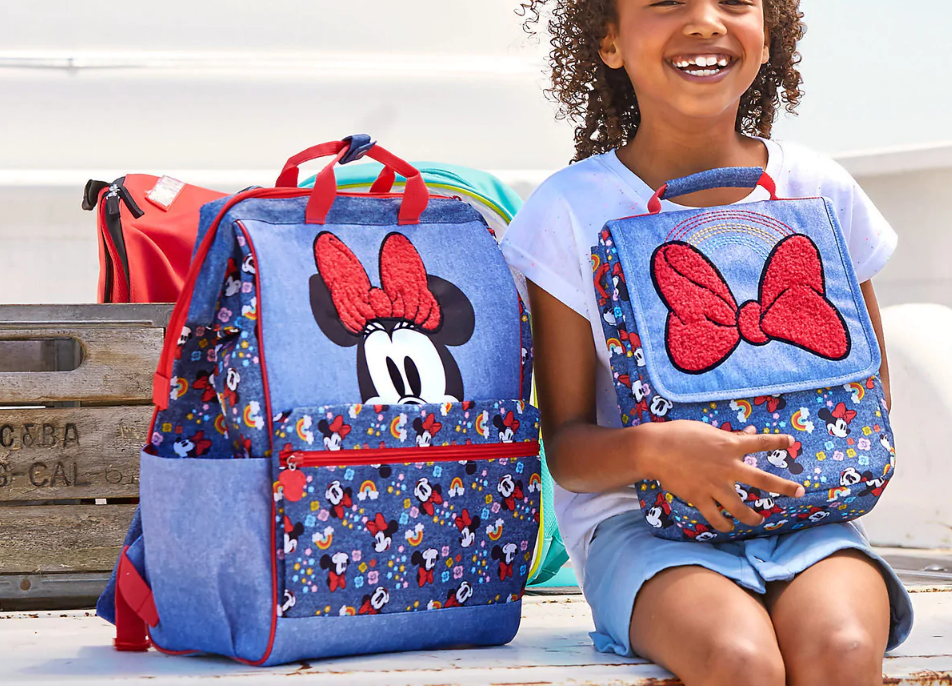 Girl holding Minnie Mouse Lunchbox with Backpack next to her