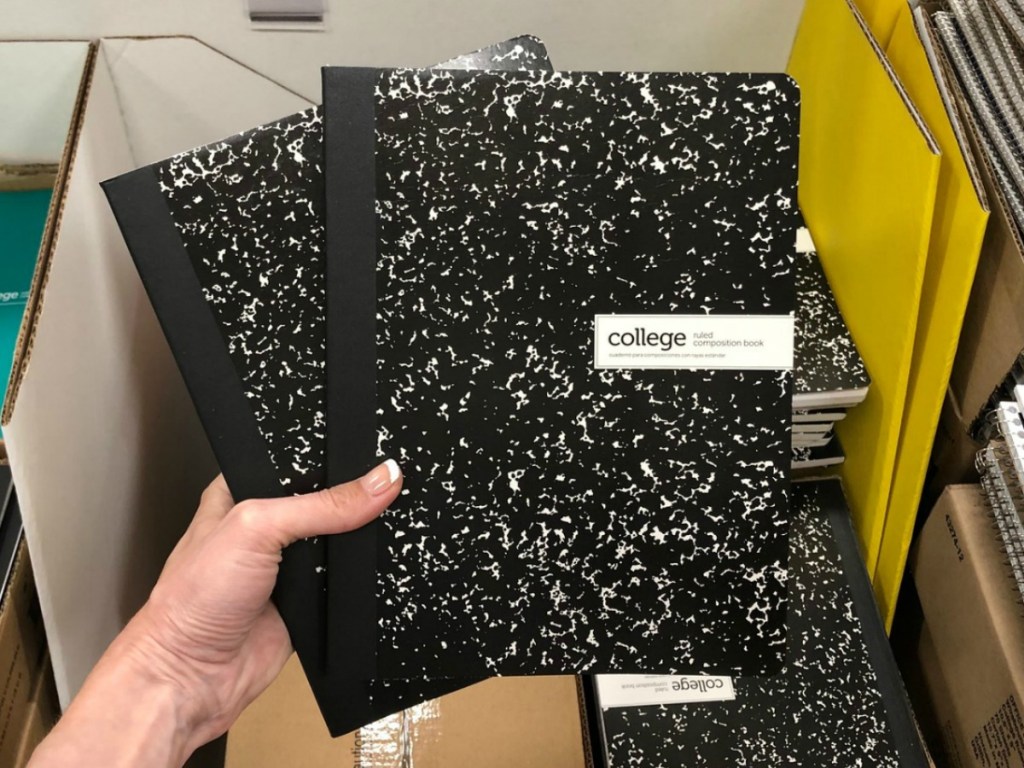 Black marble composition book held up in hand