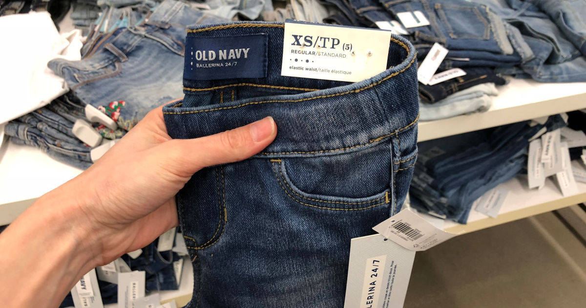 old navy girls jeans held up by woman hand in store