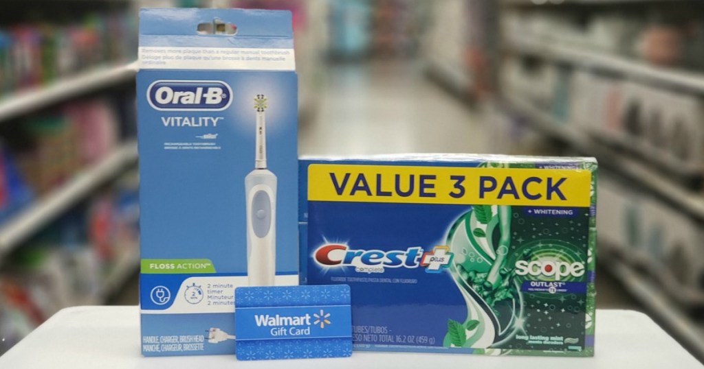 Orab B Brand electric toothbrush with Crest brand toothpaste and Walmart gift card on counter in store