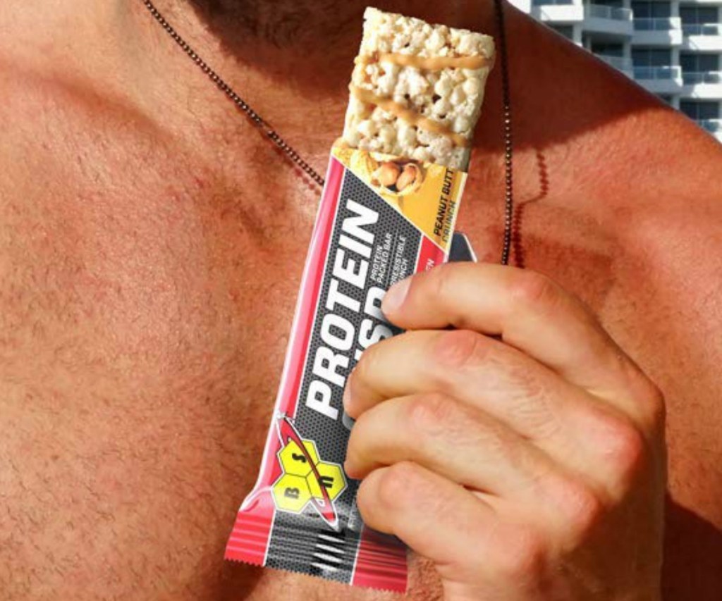 Man holding protein bar on the beach