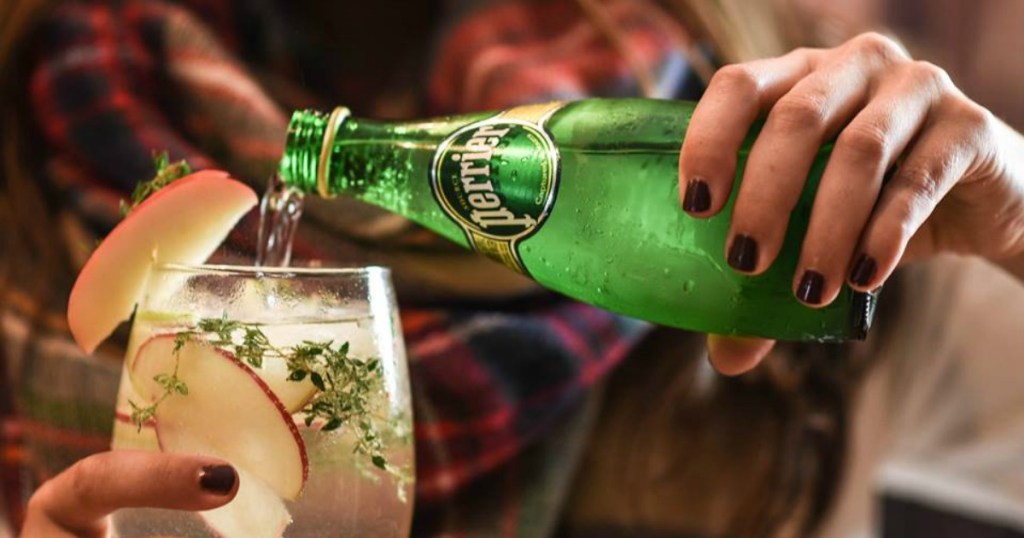 Woman pouring bottle of Perrier Sparkling water
