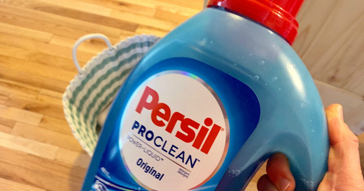 Persil Pro Clean 75 oz Liquid Detergent in person's hand with laundry basket in background