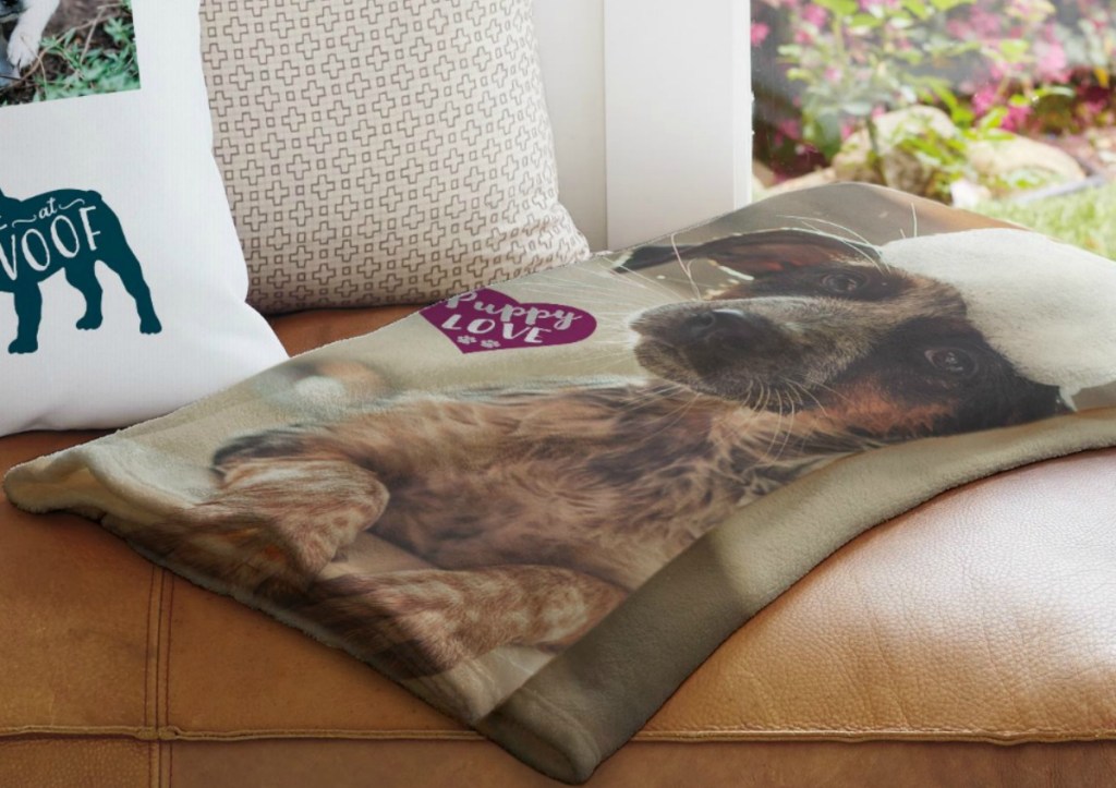 Personalized blanket from Snapfish with an image of a dog and says "Puppy Love" near a personalized pillow on a sofa