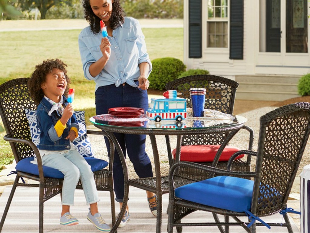 Woman and little girl eating popsicles at outdoor dining set